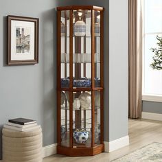 a corner display case in a living room with blue walls and white rugs on the floor