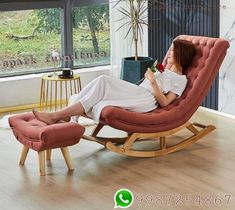 a woman sitting in a rocking chair next to a table with a plant on it