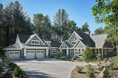 a large house with two garages and lots of trees