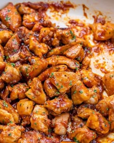 chicken with sauce and parsley in a white bowl