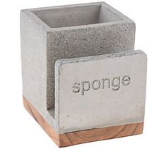 a concrete planter with the word sponge written on it and a wooden block in front