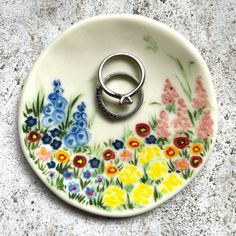 a ring holder with flowers painted on it