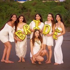 a group of women pose for a photo with balloons in the shape of letters that spell bride