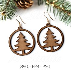 wooden earrings with trees in the center and pine cones on each earring, hanging from a christmas tree branch