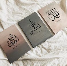 three books with arabic writing on them sitting on a bed