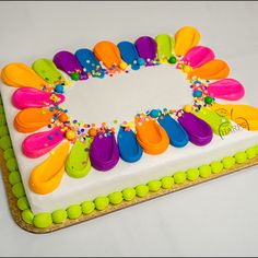 a cake decorated with colorful icing and sprinkles on a white surface