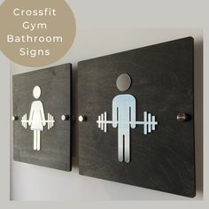 two wooden signs with the words crossfit gym bathroom signs on them, and an image of a man and a woman holding barbells