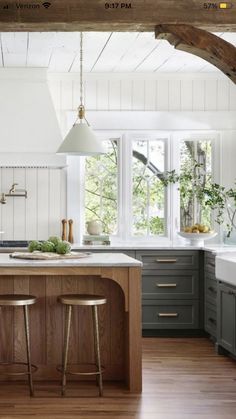 a kitchen with two stools in front of an island