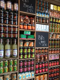 an assortment of spices and condiments on display in a store with chalkboard signs