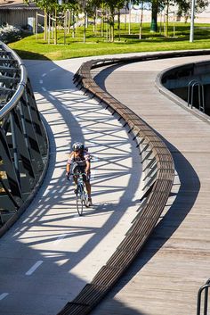 a bicyclist rides on a curved walkway