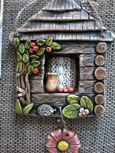 a small wooden house with flowers on the outside and a lace doily hanging from it