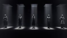 four mannequins in black and white with light streaming through them on the floor