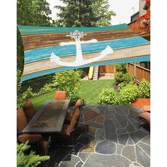 an outdoor dining area with table, chairs and large sailboat flag on the wall