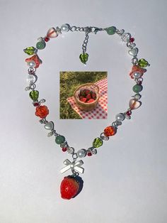 a fruit and glass beaded necklace with an image of a bowl of strawberries