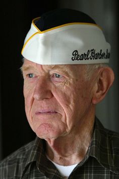 an older man wearing a hat with the word pearl harbor on it's side