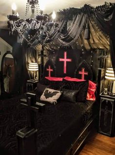 a bedroom with black and red decor, chandelier and cross on the bed