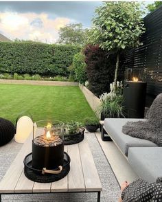 an outdoor living area with couches, table and fire pit in the middle of it