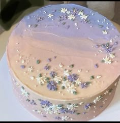 a cake with purple frosting and white flowers on it