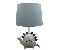 a table lamp with a blue shade on it and a white dinosaur figurine