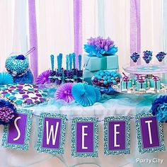 a table topped with lots of purple and blue decorations