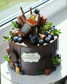 a chocolate cake decorated with blueberries and liquor bottles