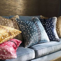 a blue couch with five different pillows on it