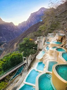 an outdoor swimming pool in the middle of a mountain range with mountains in the background