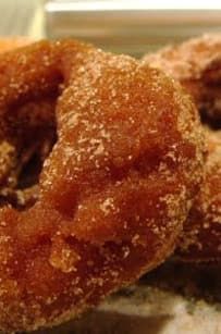 two sugared donuts sitting on top of a counter