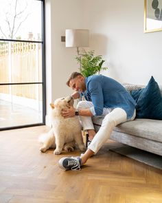 a man sitting on a couch with his dog