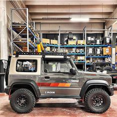 a jeep parked in a warehouse with shelves full of boxes and other items behind it