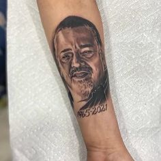 a man's arm with a portrait tattoo on it