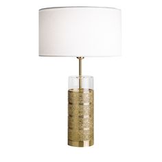 a gold table lamp with a white shade on the base and a light in front of it