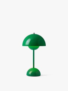 a green table lamp sitting on top of a white surface