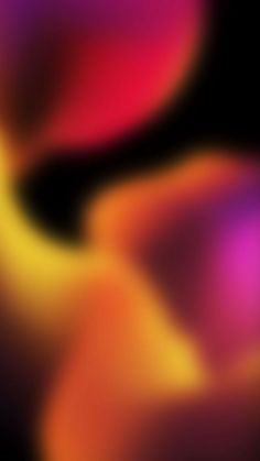 an abstract blurry image of pink and yellow curves on a black background in the dark