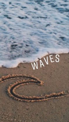 the word waves written in sand next to the ocean and wave coming toward it with an image of a heart