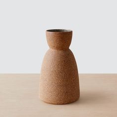 a brown vase sitting on top of a wooden table