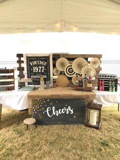 a table that has some items on it under a tent with lights and decorations around it