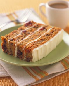 a piece of cake sitting on top of a green plate next to a cup of coffee