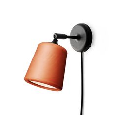 an orange wall light with a black arm