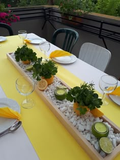 the table is set with plates and glasses on it, along with small planters