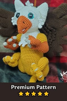 a crocheted stuffed bird sitting on top of a blanket