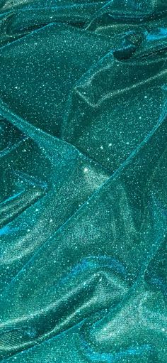 blue and green glitter fabric with small white dots on the top, as seen from above