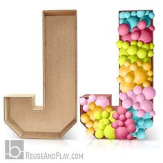 the letter j is made up of colorful balls and plastic beads, as well as a cardboard box