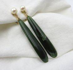 Loveliest Mid Century era Nephrite Jade and Cultured Pearl drop earrings.  The drops are a beautiful dark green jade suspended by an approximately 5mm cultured pearl with very nice luster.  These classic earrings secure with clip backs of 12kt gold. Approximate measurements: Pearl to end of Jade drop: 7.5 cm or 2.95 inches. To Note:  The gold rings suspending the pearls, cast a shadow at the bottom of the pearls.  No flaw, just shadow. (: Green Pearls Jewelry, Pear Accessories, Jade And Gold Jewelry, Jade Earrings Drop, Green Pearl Jewelry, Unique Wedding Jewelry, Nephrite Jade, Funky Earrings, Classic Earrings