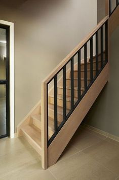 a wooden stair case next to a glass door