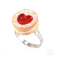 a heart shaped pastry on top of a silver ring