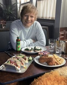 a woman sitting at a table with plates of food