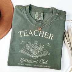 a t - shirt that reads teacher retirement club next to a hat