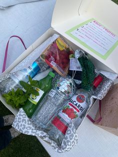 an open box filled with different types of food and drinks on top of a table