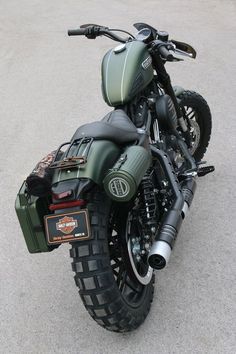 a green motorcycle parked on top of a parking lot